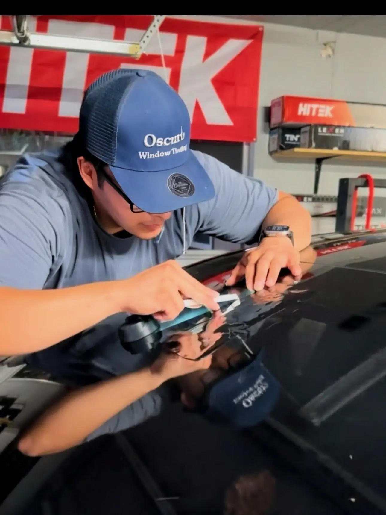 Juan, owner of Oscuro Tintz, hand-cutting window tint film in Yuba City, CA